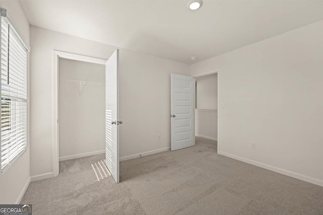 unfurnished bedroom featuring a closet and light colored carpet