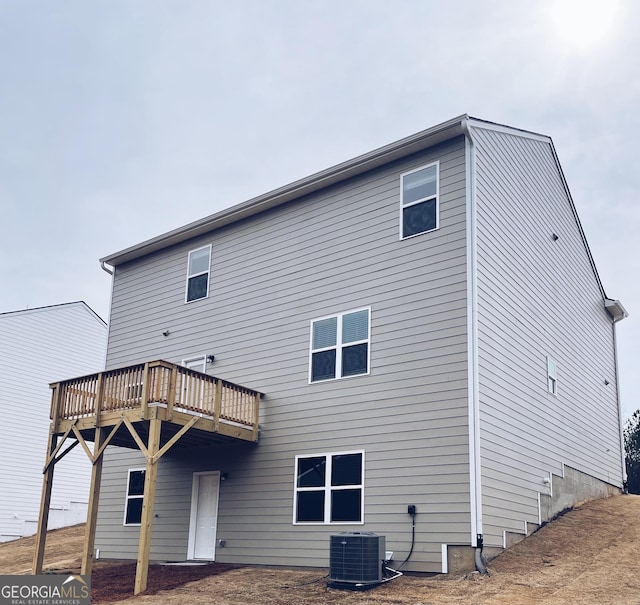 back of house featuring a wooden deck and central air condition unit