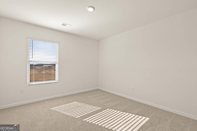 unfurnished room featuring light carpet