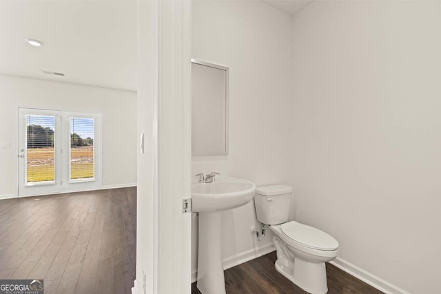 bathroom featuring toilet, sink, and hardwood / wood-style flooring