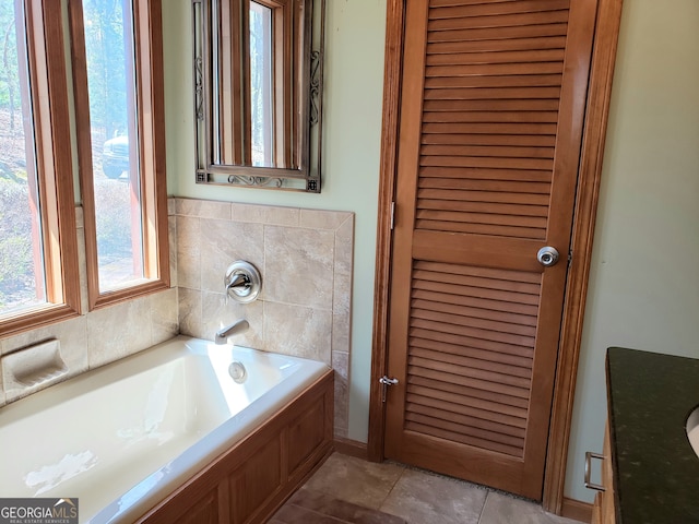 bathroom featuring a bath to relax in and tile flooring