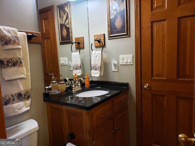 bathroom featuring vanity with extensive cabinet space and toilet