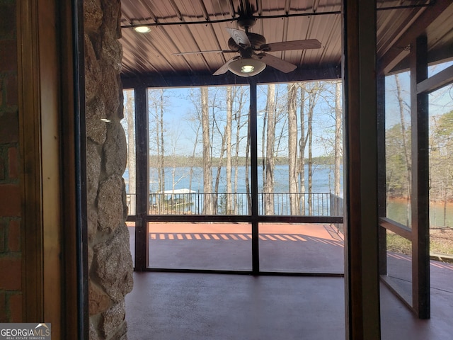 unfurnished sunroom with a water view, wood ceiling, and ceiling fan