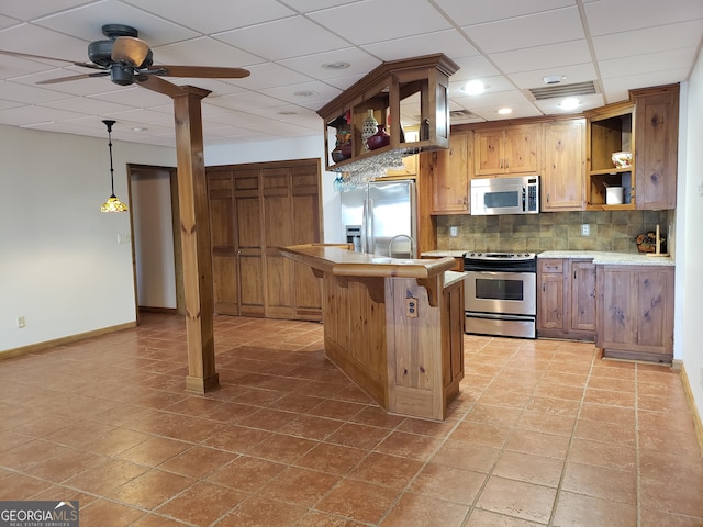 kitchen with decorative light fixtures, ceiling fan, stainless steel appliances, a paneled ceiling, and light tile floors