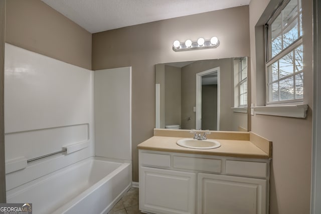 bathroom with  shower combination, tile floors, a textured ceiling, and vanity