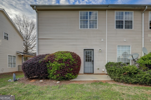 back of property with a patio area and a yard