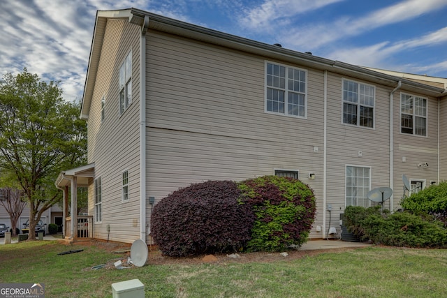 view of side of home with a yard