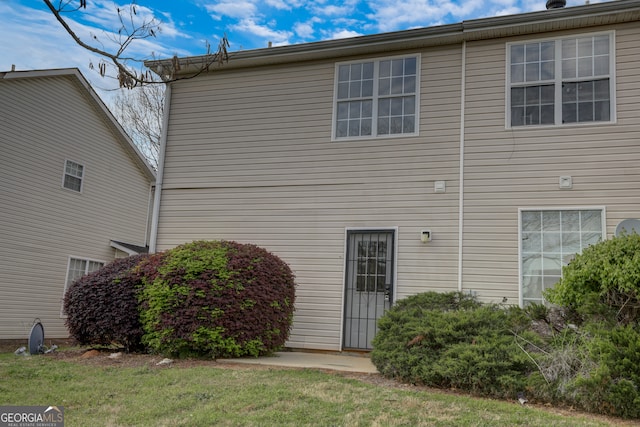 rear view of property featuring a lawn