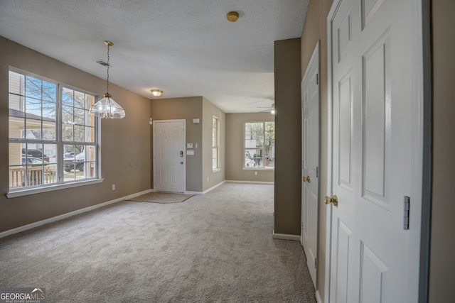 interior space with a textured ceiling, ceiling fan with notable chandelier, and a wealth of natural light