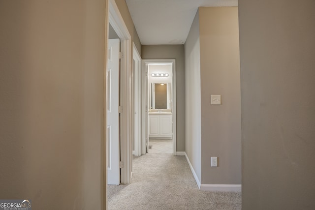 hallway featuring light carpet and sink