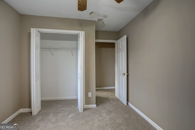 unfurnished bedroom with light carpet, a closet, and ceiling fan