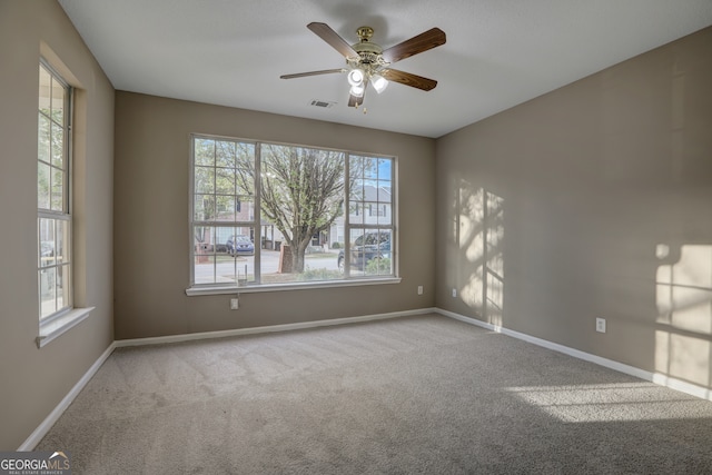 carpeted spare room featuring ceiling fan