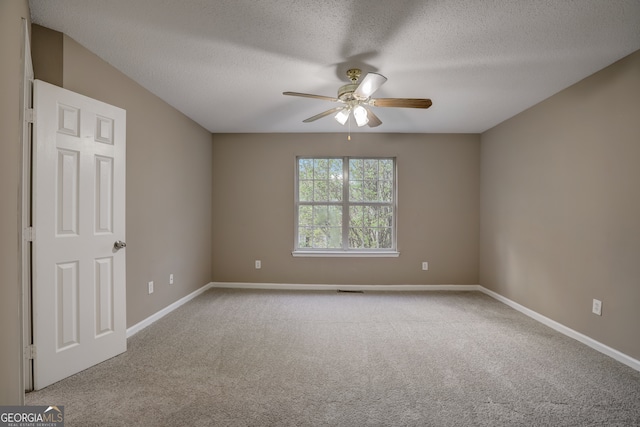 carpeted spare room featuring a textured ceiling and ceiling fan