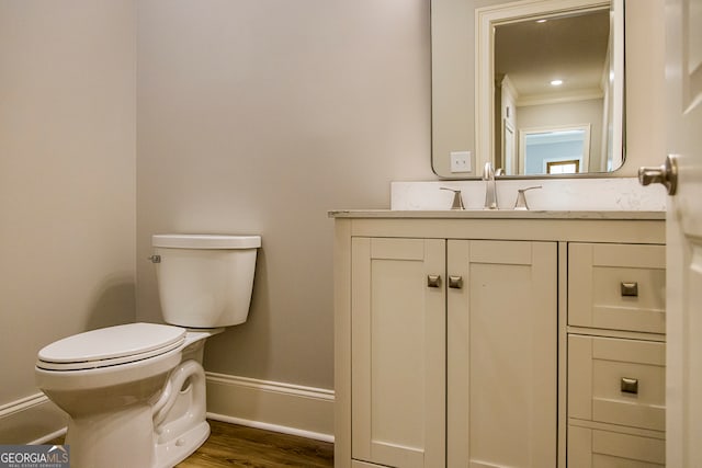 bathroom featuring crown molding, toilet, wood-type flooring, and vanity