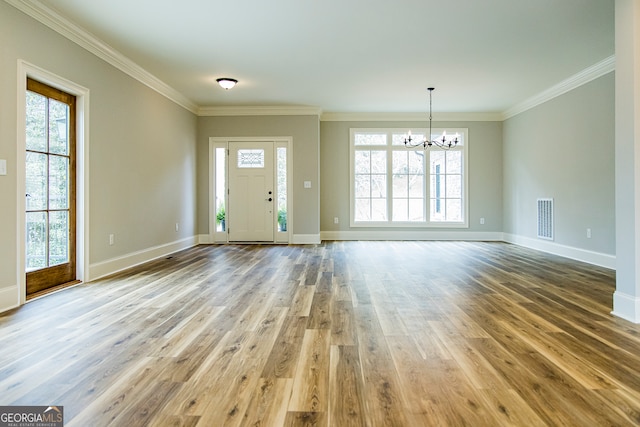 entryway with plenty of natural light, hardwood / wood-style flooring, and a chandelier