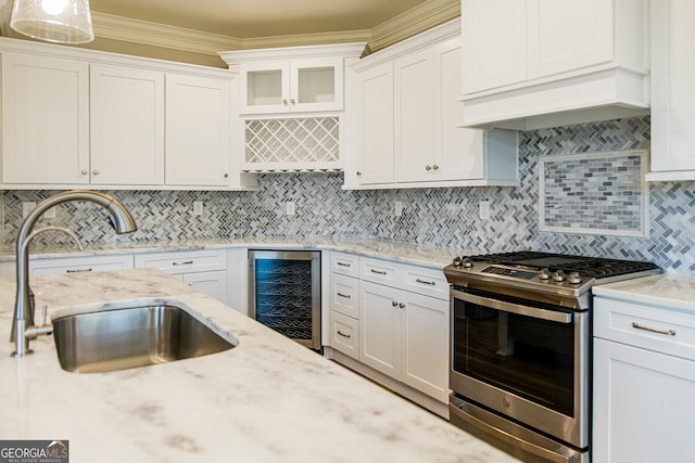 kitchen with white cabinets, beverage cooler, tasteful backsplash, and stainless steel gas range