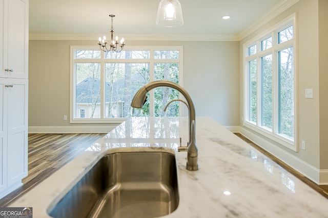 room details featuring sink, a notable chandelier, ornamental molding, and wood-type flooring