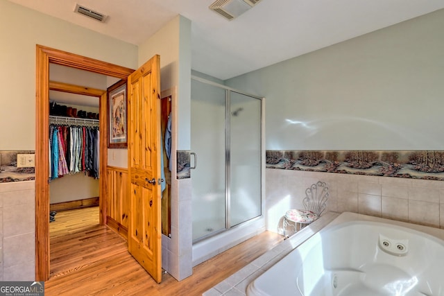 bathroom featuring separate shower and tub and wood-type flooring