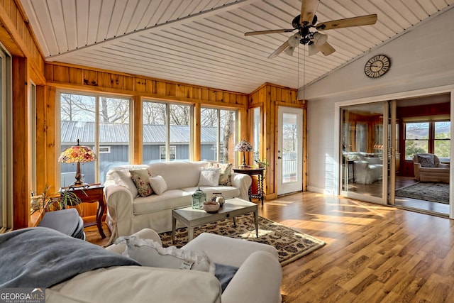 sunroom / solarium with ceiling fan, vaulted ceiling, wooden ceiling, and a healthy amount of sunlight