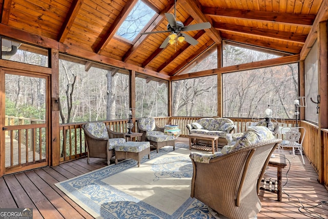 sunroom / solarium featuring ceiling fan, vaulted ceiling with skylight, and wooden ceiling