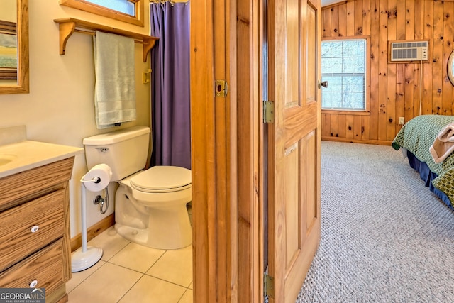 bathroom with wooden walls, vanity, tile patterned floors, toilet, and a wall mounted AC