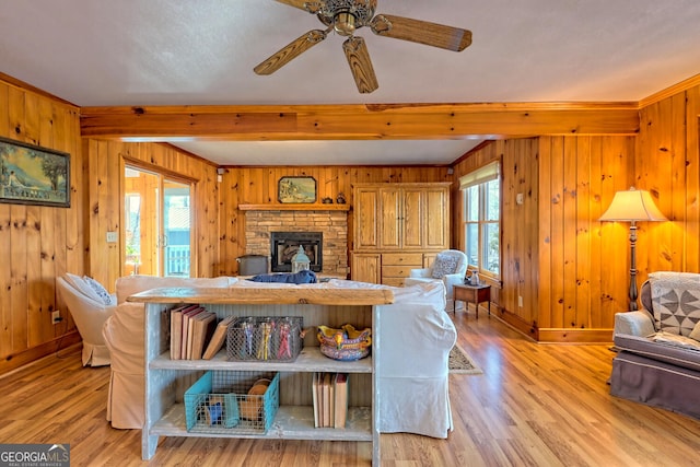 living room featuring wood walls, light hardwood / wood-style flooring, and ceiling fan