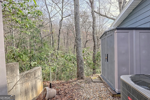 view of yard featuring a storage shed and central air condition unit