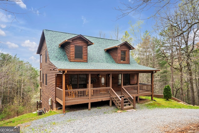 log cabin featuring covered porch