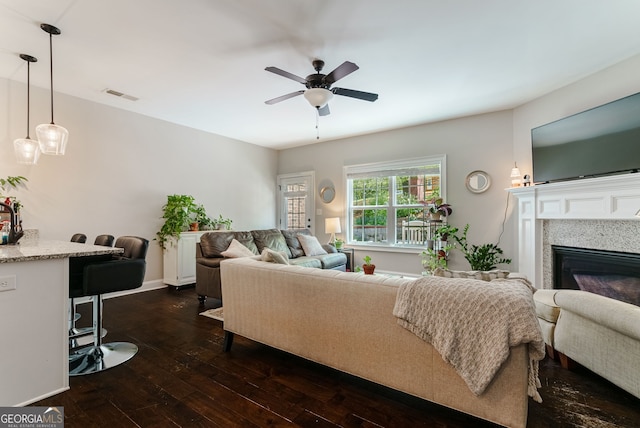 living room featuring ceiling fan and dark wood-type flooring