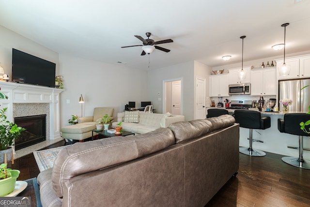 living room with ceiling fan and dark wood-type flooring