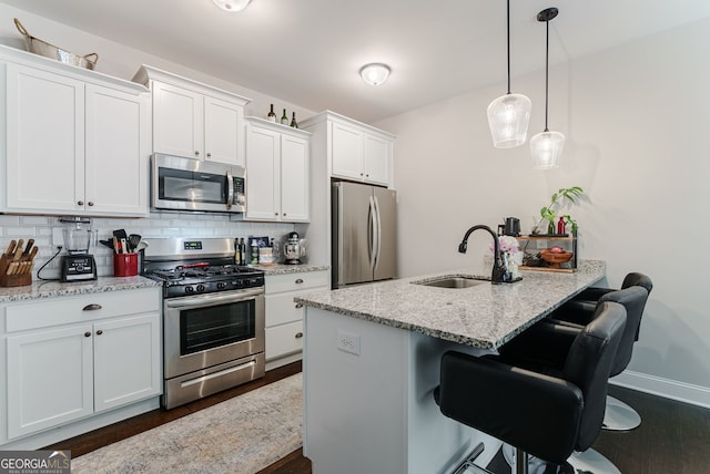 kitchen featuring dark hardwood / wood-style floors, tasteful backsplash, appliances with stainless steel finishes, and sink