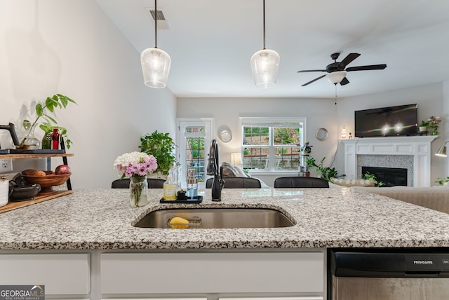 kitchen with decorative light fixtures, ceiling fan, and light stone countertops