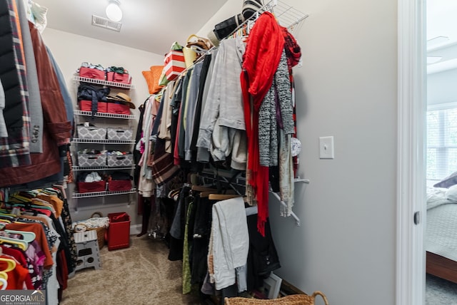 walk in closet with dark colored carpet