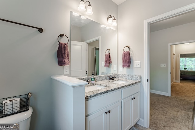 bathroom with double vanity and toilet