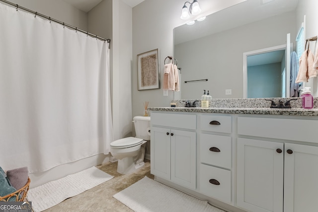 bathroom featuring vanity, tile floors, and toilet