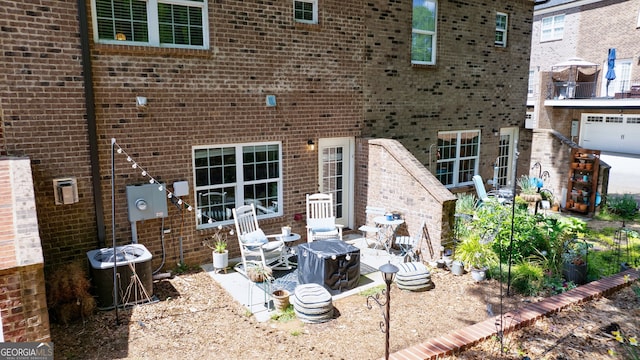 back of property with central AC unit, a patio area, and a garage