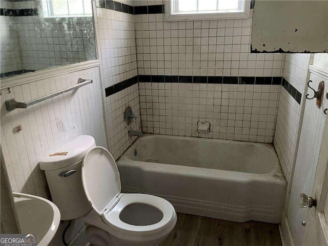 bathroom featuring toilet, hardwood / wood-style flooring, and a healthy amount of sunlight