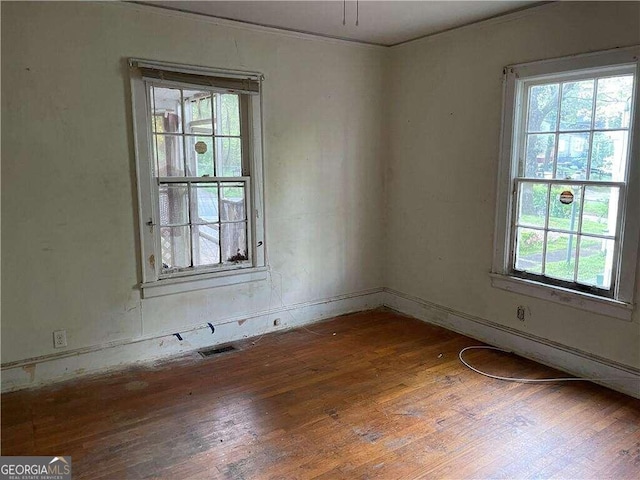 unfurnished room featuring plenty of natural light and dark hardwood / wood-style flooring