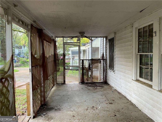 unfurnished sunroom featuring ceiling fan