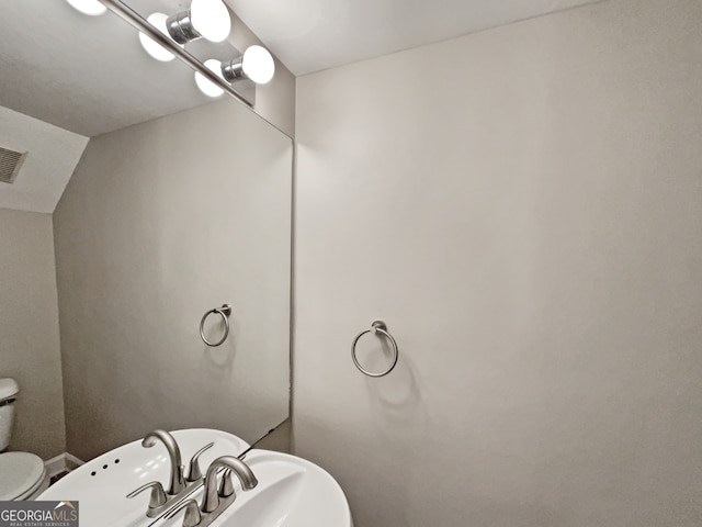 bathroom featuring toilet and vaulted ceiling