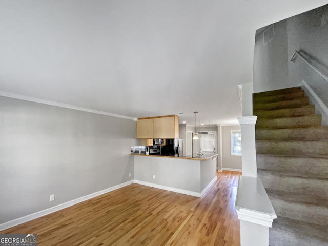 unfurnished living room with ornamental molding and hardwood / wood-style flooring