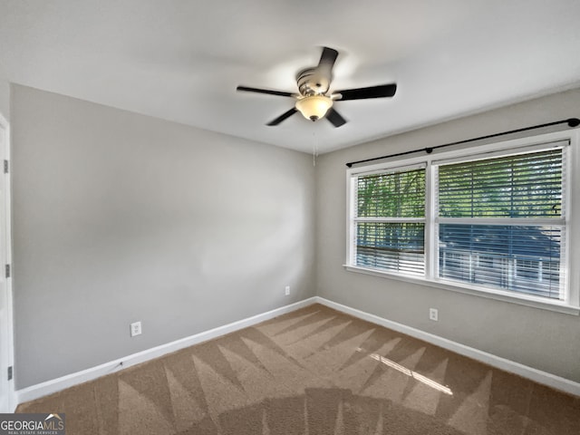 carpeted spare room featuring ceiling fan