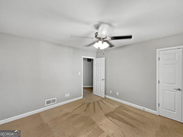 empty room with ceiling fan and light carpet