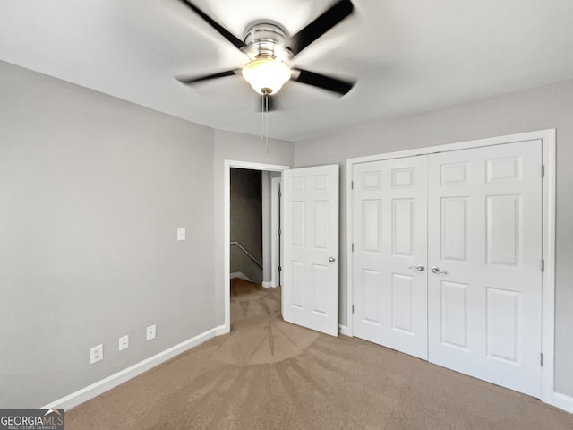 unfurnished bedroom featuring light colored carpet, a closet, and ceiling fan