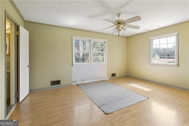 spare room with crown molding, light hardwood / wood-style flooring, and ceiling fan