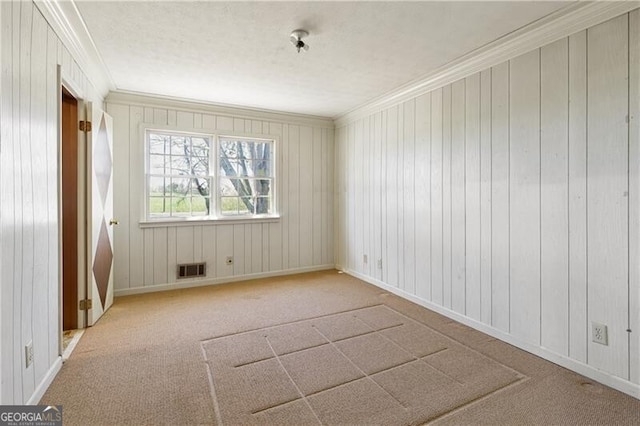 spare room featuring ornamental molding and light colored carpet