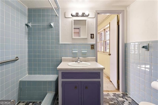 bathroom featuring vanity, tile walls, and a tile shower