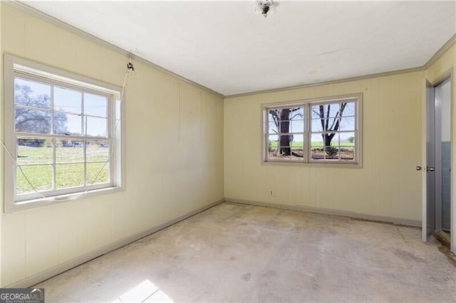 empty room featuring crown molding and a wealth of natural light