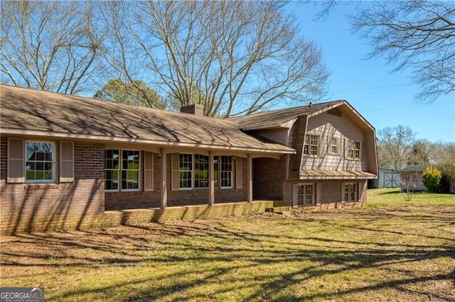 rear view of property featuring a lawn