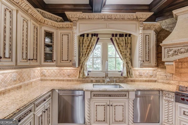 kitchen with tasteful backsplash, cream cabinetry, dishwasher, and sink